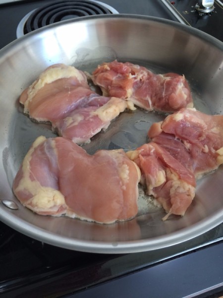 Lightly browning chicken breasts.