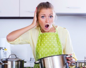 Woman with shocked look on her face holding  a cooking pot