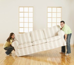 Man and woman carrying a large couch