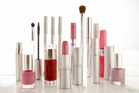Tubes and bottles of makeup standing upright against a white background