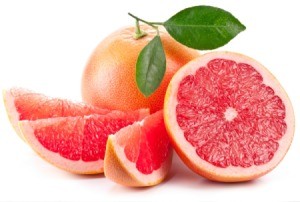 A cut up grapefruit and a whole grapefruit.
