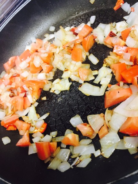 Vegetables being sauteed before being placed in an empanada.