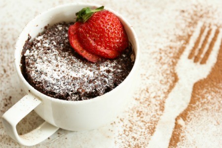 Chocolate mug cake garnished with a sliced strawberry