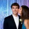 Girl in prom dress kissing boy in suit on the cheek
