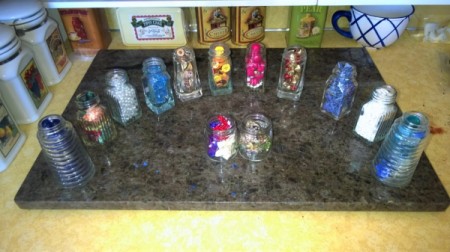 an array of spice bottles filled with other things such as buttons