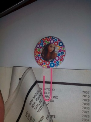 A colorful circular paper photo frame bookmark on page of book.