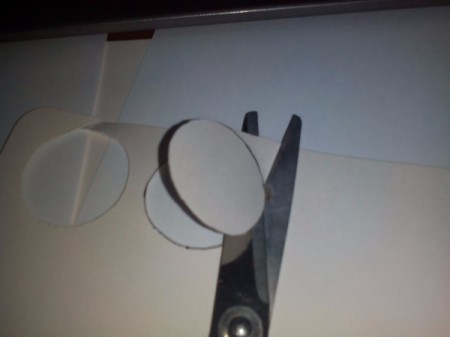 Cutting out back of frame with scissors.