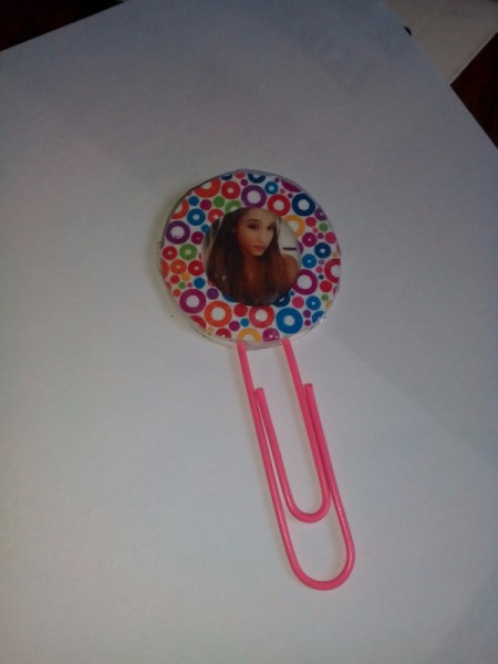 Photo inserted into frame. Bookmark lying on white paper background.