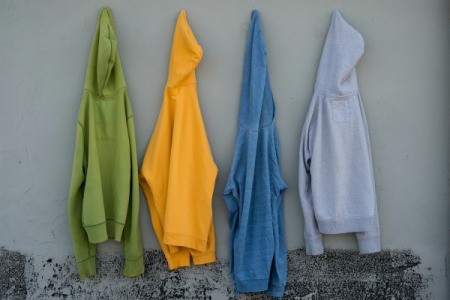 Four old sweatshirts hanging on a wall