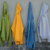 Four old sweatshirts hanging on a wall
