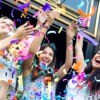 Teen girls throwing bright confetti outside