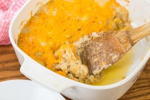 Crab au gratin being spooned out of a casserole dish