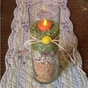 Candle vase filled with dried beans and peas.