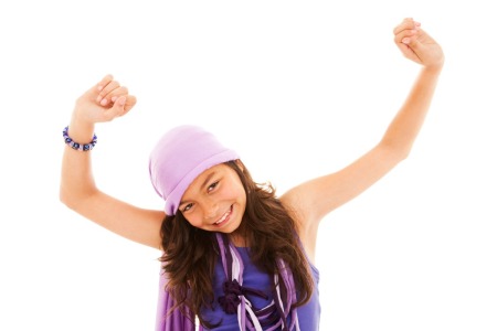 Tween girl dancing against a white background