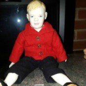 male doll wearing red coat and black pants