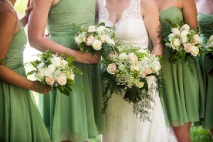 bridesmaids in green dresses standing next to bride