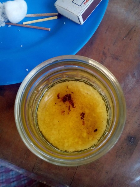 View of the open jar with salt layer and oil.
