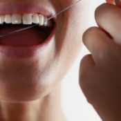 Close up of woman's teeth being flossed