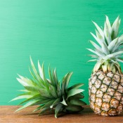 Pineapple and top of pineapple against green background