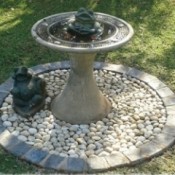 birdbath on circle of small cobbles with border