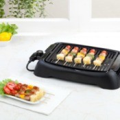 Electric table top grill with Kabobs on it