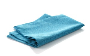 Folded blue cloth napkin on white background