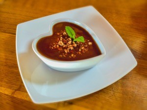 Chocolate pudding with tapioca and nut topping in a white heart shaped dish