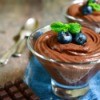 Diet chocolate pudding topped with blueberries in a glass serving cup