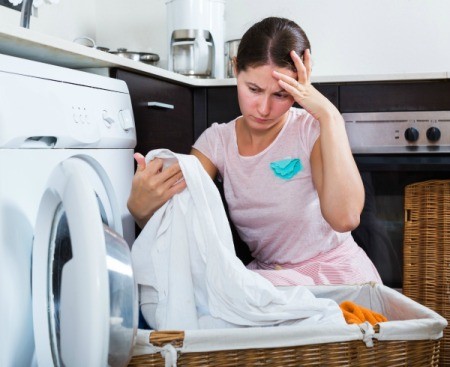 Concerned looking woman checking clean laundry for stains