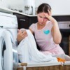 Concerned looking woman checking clean laundry for stains