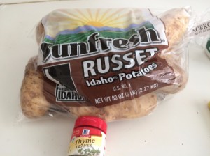 A bag of potatoes and some dried thyme in a spice bottle.