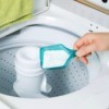 Powdered laundry detergent being added to top load washer