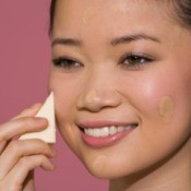 Woman applying foundation to skin with a make-up sponge