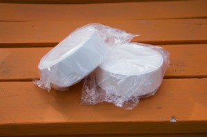 Two packaged chlorine pucks laying on a wooden deck.