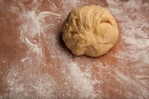 Ball of pizza dough on flour dusted work surface