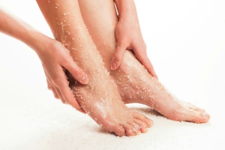Hands massaging a sugar scrub into feet