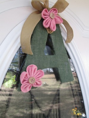 A green letter "A" with pink flowers decorating a door.