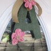 A green letter "A" with pink flowers decorating a door.