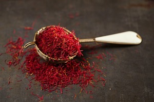 Measuring spoon spilling over with saffron threads