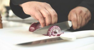 Chef chopping red onion