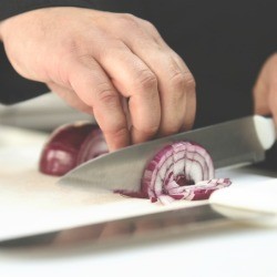 Chef chopping red onion
