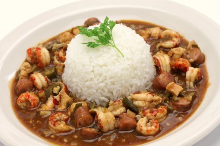 Mound of rice surrounded by shrimp gumbo.