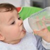 Infant drinking water from a bottle