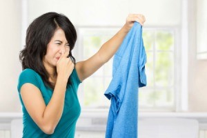 A woman holding stinky clothes.