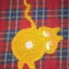 Crochet coaster of a cat looking back over its shoulder.