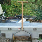 Reel mower leaning on tool box.