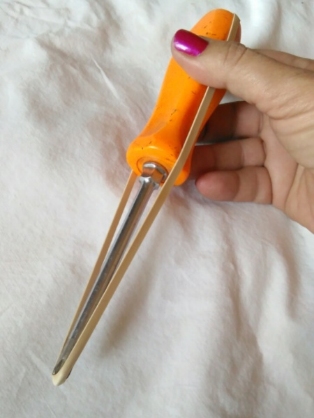 A rubber band over a screwdriver.