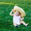 A baby wearing a overly large straw hat.