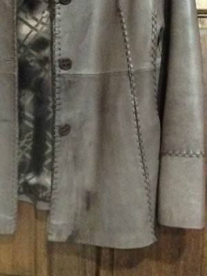 Several dark stains on gray leather jacket.