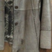 Several dark stains on gray leather jacket.